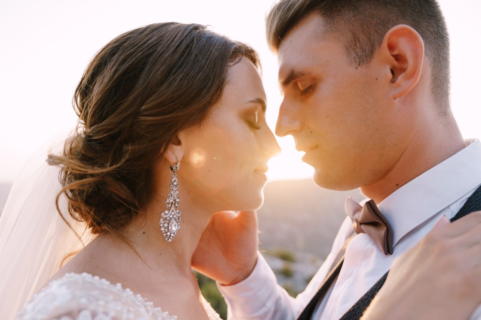 Novio con traje claro y pajarita marrón en su boda