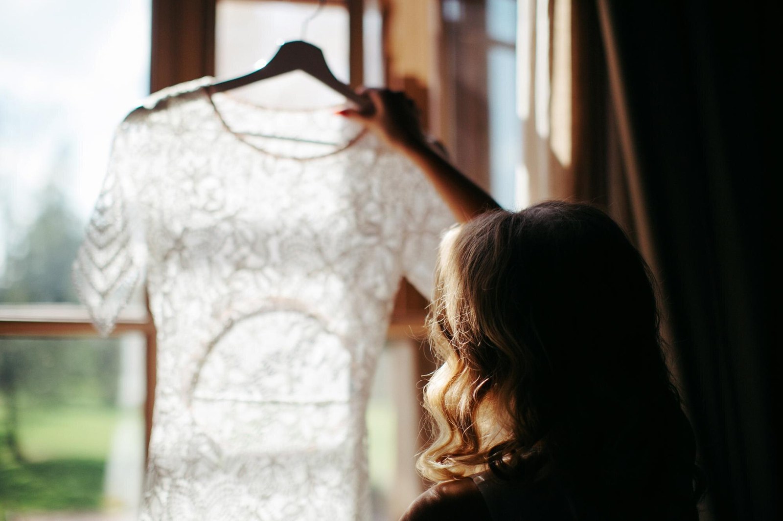 Novia revisando un vestido de encaje antes de la prueba