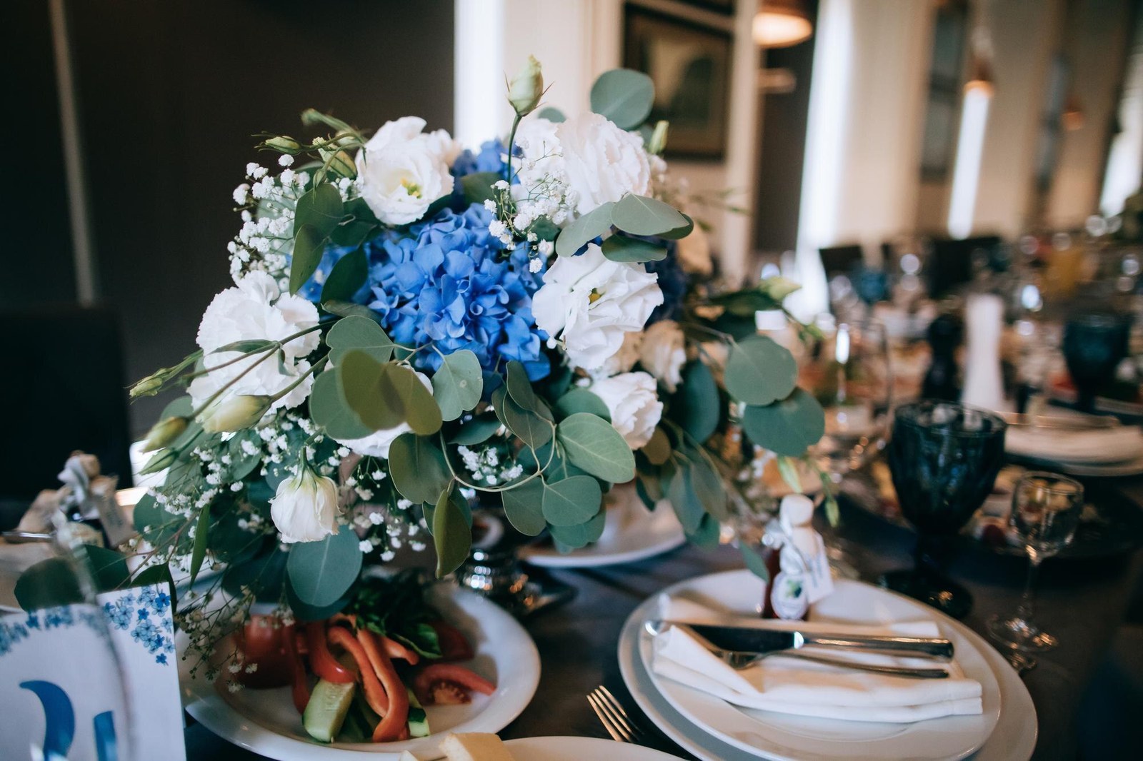 Mesa de boda decorada con flores azules y blancas